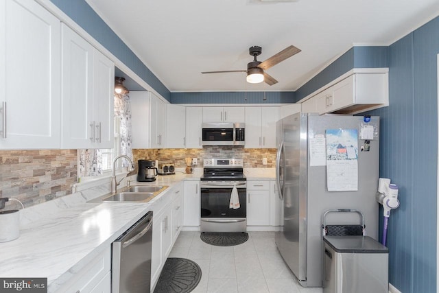 kitchen with white cabinets, ceiling fan, sink, and stainless steel appliances