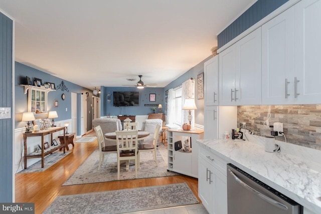 kitchen featuring white cabinetry, dishwasher, ceiling fan, light stone counters, and decorative backsplash