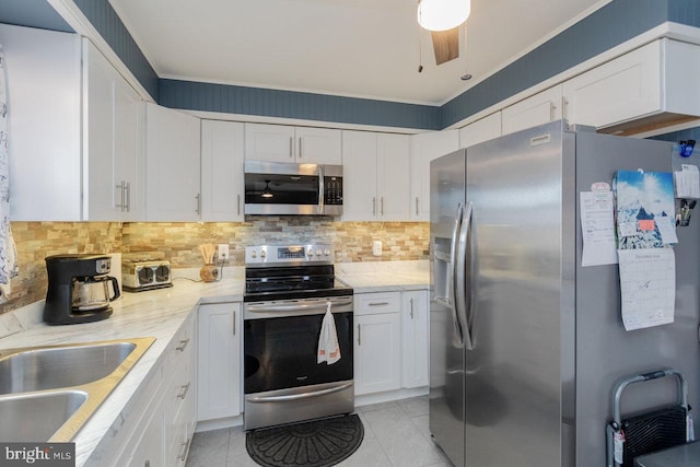 kitchen with light stone countertops, sink, white cabinets, and stainless steel appliances