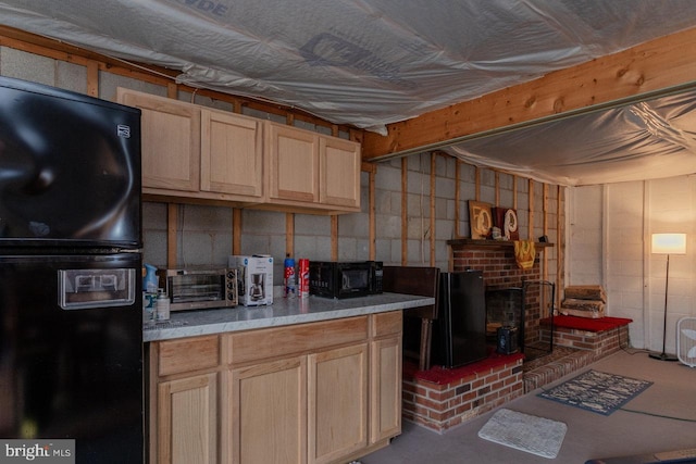 kitchen featuring light brown cabinets, concrete floors, and black appliances