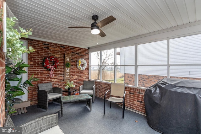 sunroom with ceiling fan and wooden ceiling