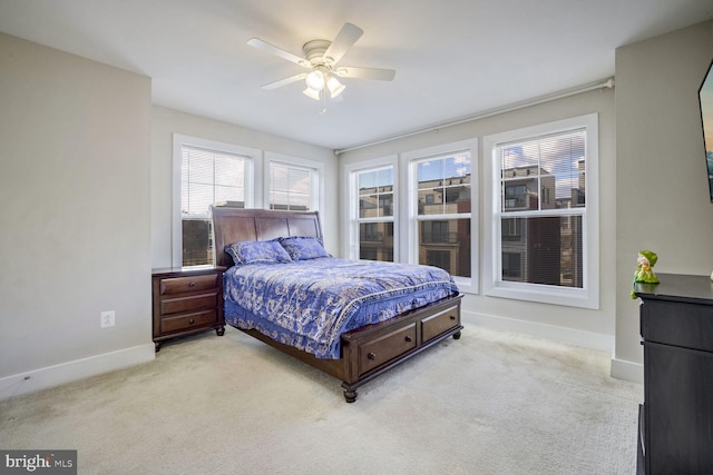 bedroom with ceiling fan and light colored carpet