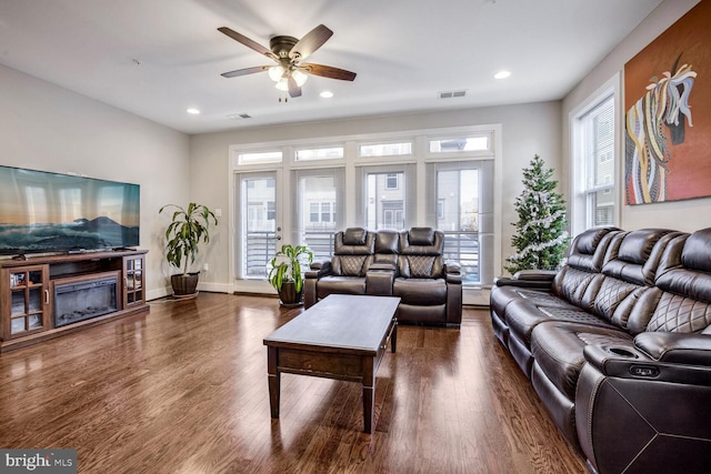 living room with dark hardwood / wood-style flooring and ceiling fan