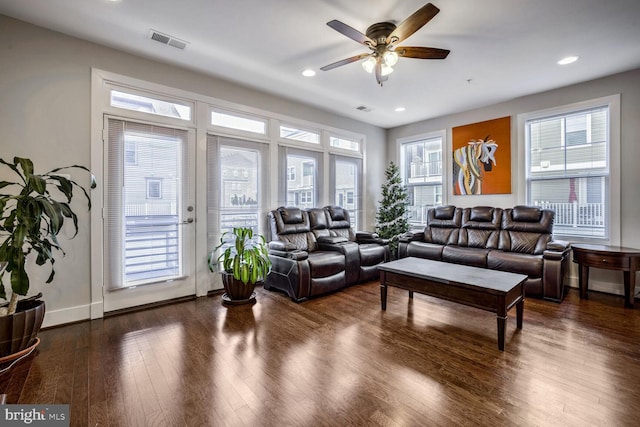 living room featuring ceiling fan and dark wood-type flooring