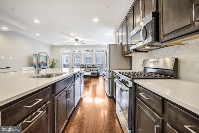 kitchen featuring backsplash, sink, ceiling fan, appliances with stainless steel finishes, and dark hardwood / wood-style flooring