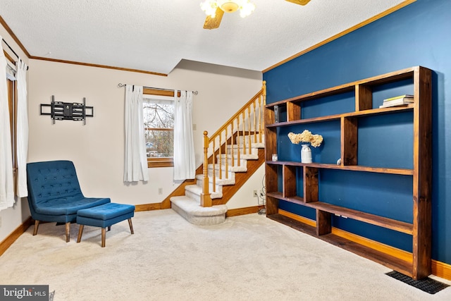 living area with carpet flooring, a textured ceiling, and crown molding