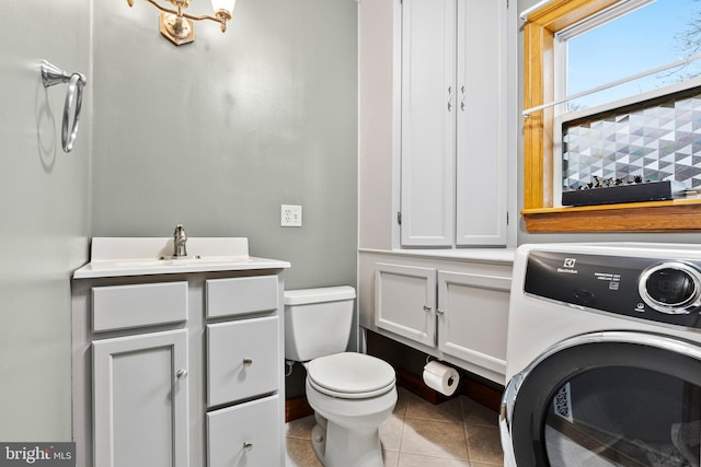 bathroom featuring tile patterned floors, vanity, toilet, and washer / dryer