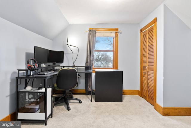 carpeted home office featuring vaulted ceiling