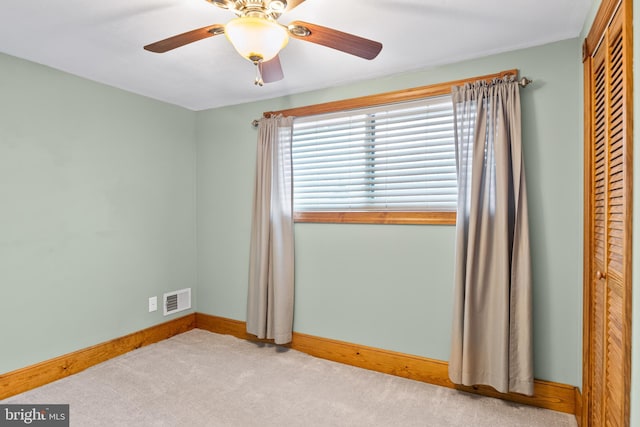 carpeted bedroom with ceiling fan and a closet