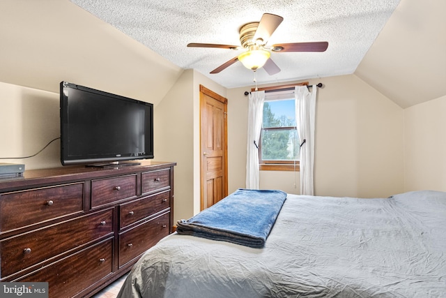 bedroom with ceiling fan, a textured ceiling, and vaulted ceiling