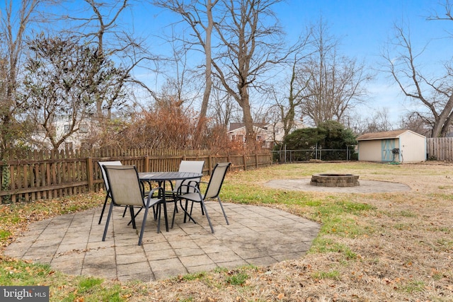 view of patio featuring a shed and an outdoor fire pit