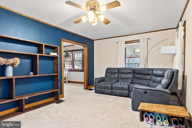 carpeted living room with ceiling fan, ornamental molding, and a textured ceiling