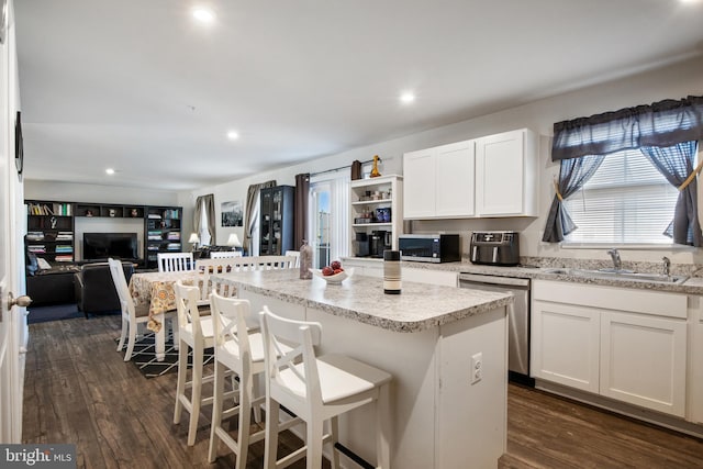 kitchen with appliances with stainless steel finishes, a center island, white cabinetry, and sink