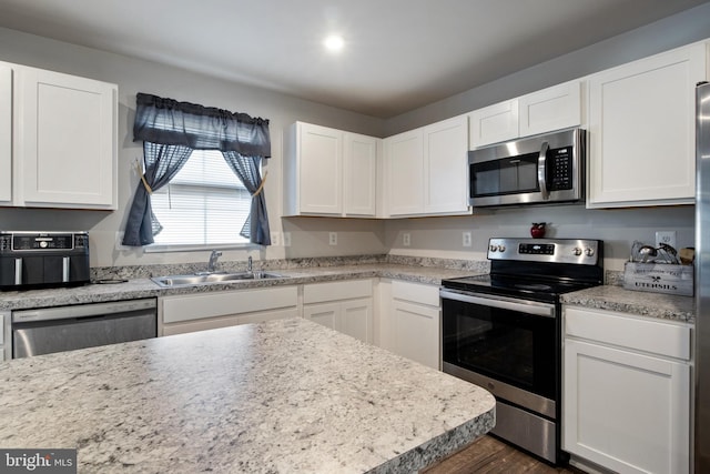 kitchen with white cabinetry, sink, and stainless steel appliances