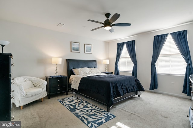 carpeted bedroom featuring ceiling fan and multiple windows