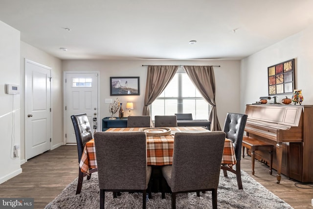 dining area with plenty of natural light and hardwood / wood-style flooring