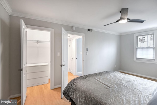 bedroom with light wood-type flooring, a closet, ceiling fan, and ornamental molding