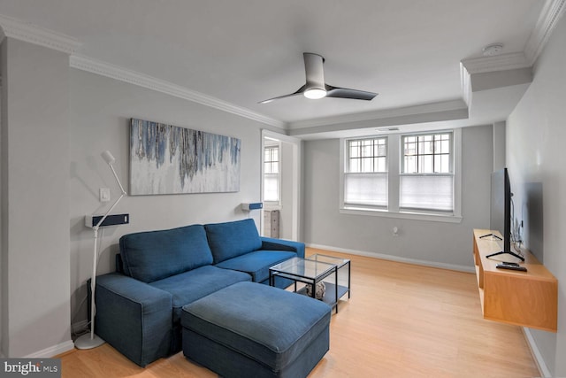 living room featuring light hardwood / wood-style flooring, ceiling fan, and crown molding