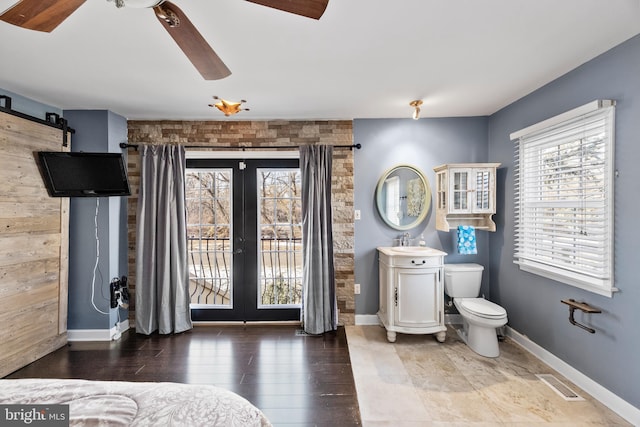 bedroom with french doors, sink, ceiling fan, a barn door, and wood-type flooring