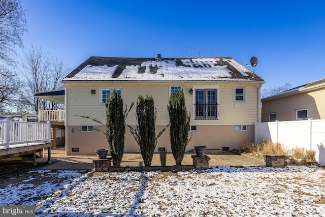 snow covered house featuring a deck