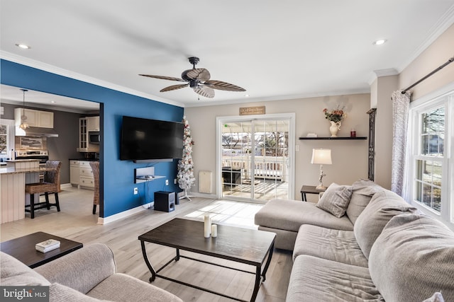 living room with ornamental molding, ceiling fan, and a healthy amount of sunlight