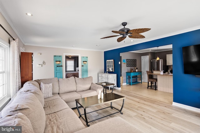 living room featuring light wood-type flooring, ceiling fan, and crown molding