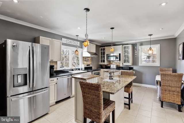 kitchen with dark stone counters, stainless steel appliances, light tile patterned floors, pendant lighting, and a center island