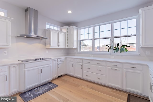 627 Halsey Way, Oxon Hill, MD 20745 - kitchen with wall chimney range hood, white cabinets, light wood-style floors, black electric stovetop, and recessed lighting