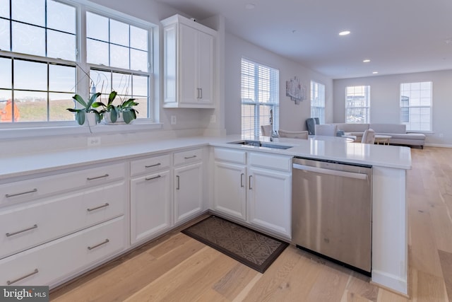 kitchen featuring dishwasher, light wood-type flooring, kitchen peninsula, and white cabinets