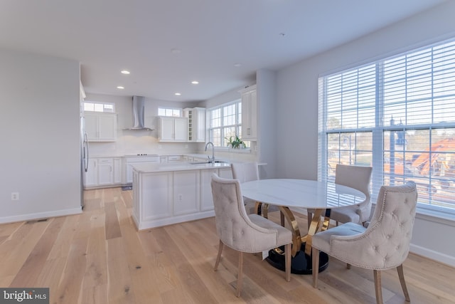 dining space with light wood-type flooring and sink