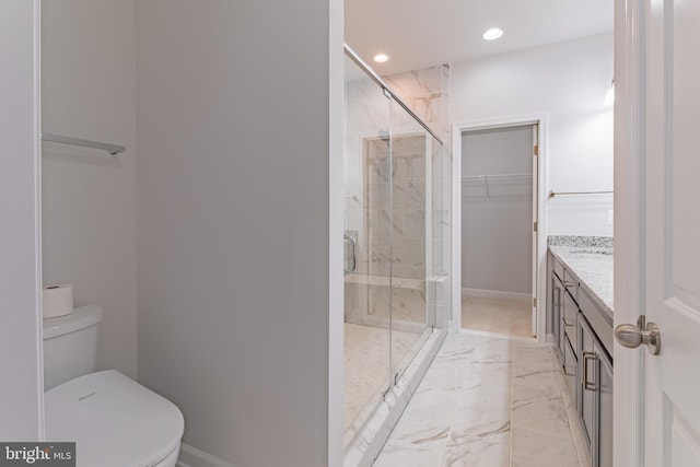 bathroom featuring vanity, toilet, and a shower with door