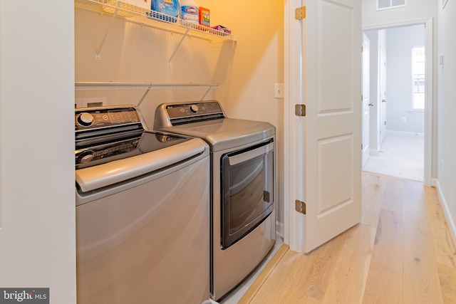 laundry area featuring light wood-type flooring and independent washer and dryer