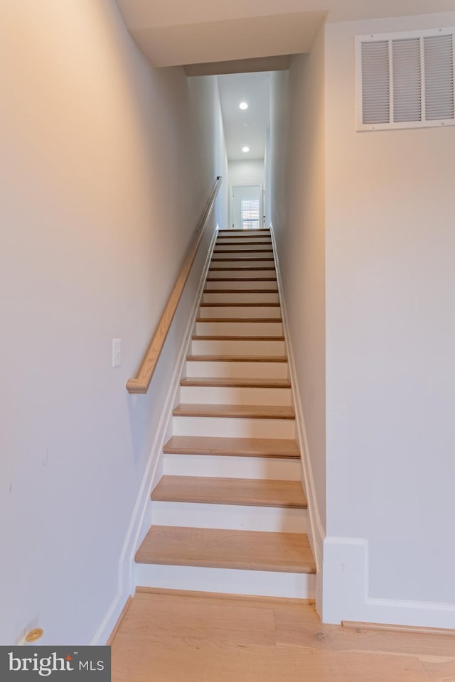 staircase with hardwood / wood-style flooring