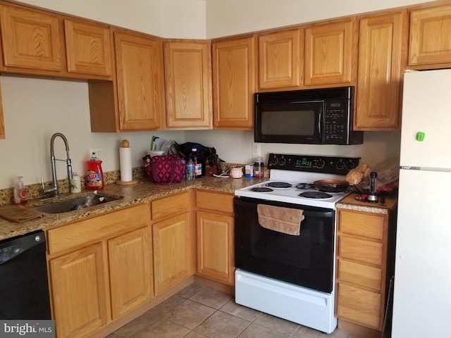 kitchen featuring light stone countertops, light tile patterned floors, sink, and black appliances