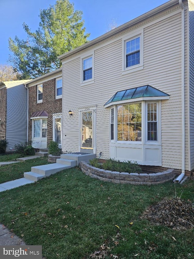 view of front of home with a front yard, a standing seam roof, and metal roof