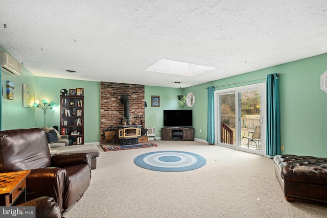 carpeted living room with a wood stove, a textured ceiling, a wall unit AC, and a skylight