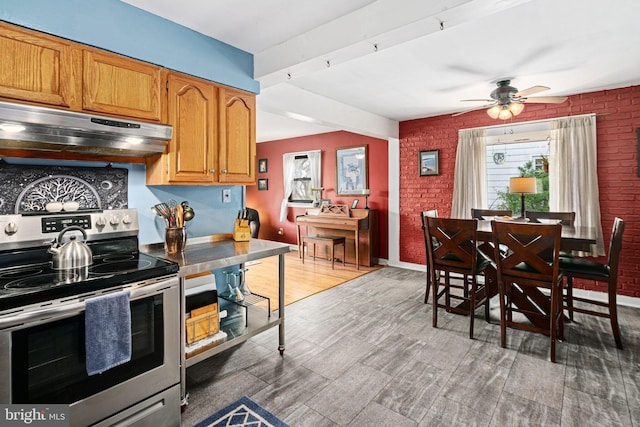 kitchen with ceiling fan, stainless steel electric range oven, brick wall, and exhaust hood