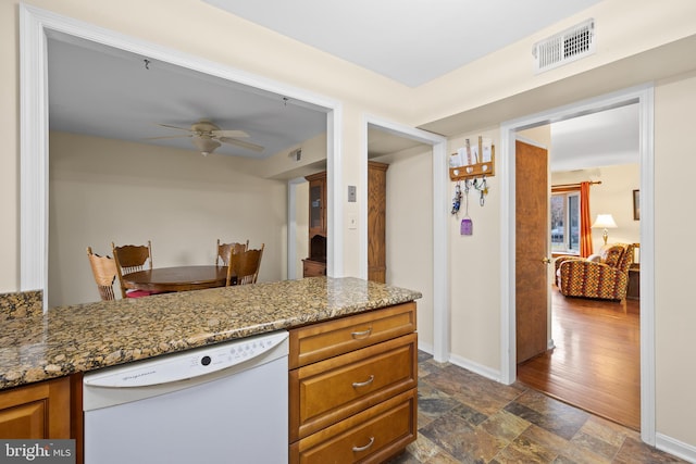 kitchen with light stone counters, dishwasher, and ceiling fan