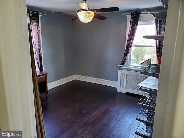 empty room with dark hardwood / wood-style floors and ceiling fan