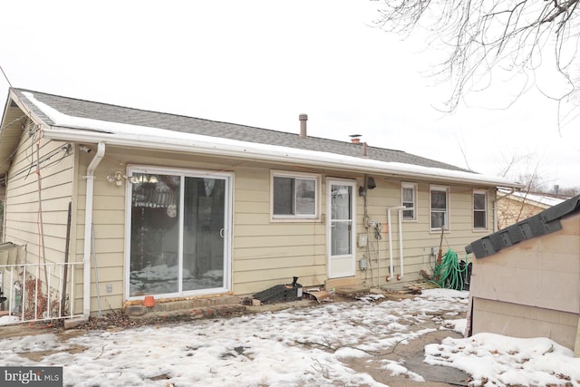 view of snow covered rear of property