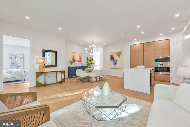 living room featuring light hardwood / wood-style floors and an inviting chandelier