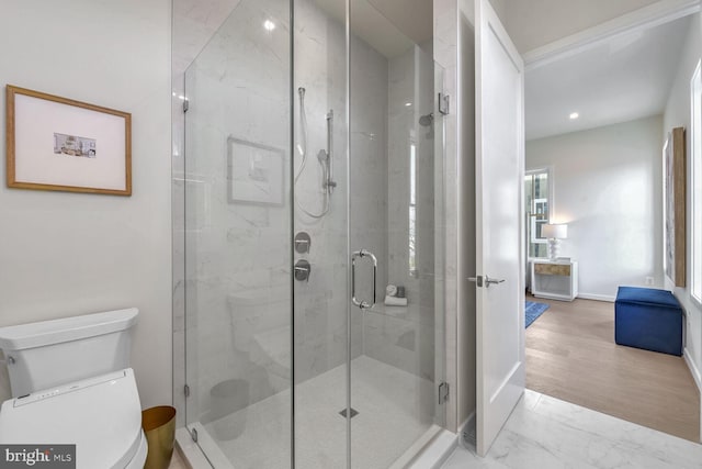 bathroom featuring wood-type flooring, toilet, and an enclosed shower