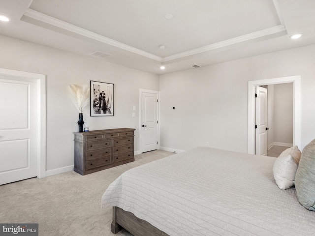 carpeted bedroom with a tray ceiling and ornamental molding