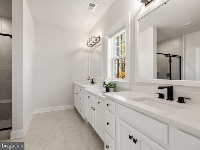 bathroom featuring tile patterned flooring, vanity, and walk in shower