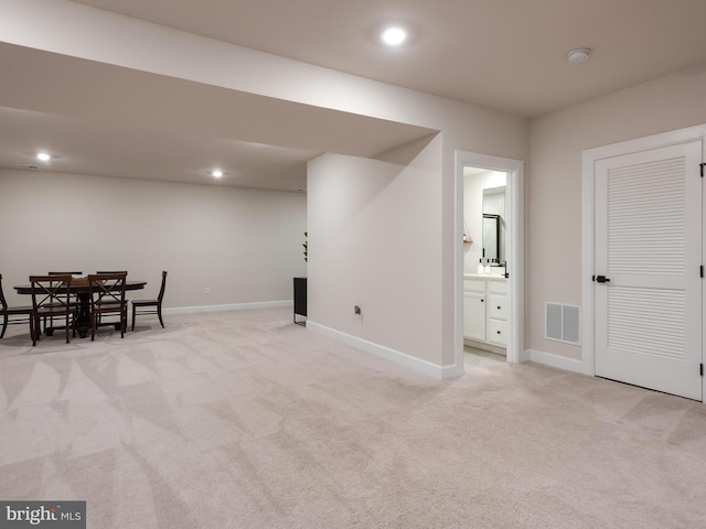 basement featuring light colored carpet