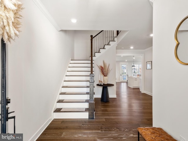 entryway featuring crown molding and dark wood-type flooring