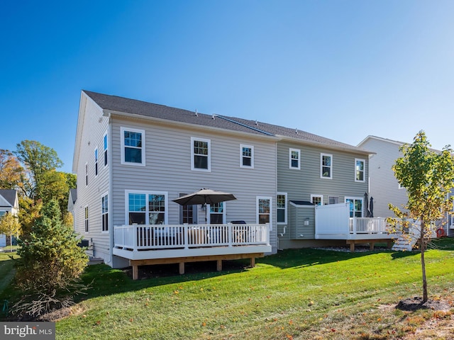 back of property with a yard and a deck