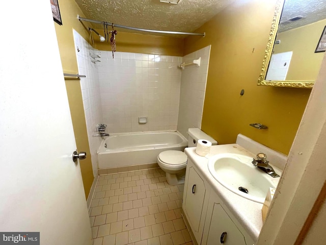 full bathroom featuring tile patterned floors, vanity, a textured ceiling, tiled shower / bath combo, and toilet