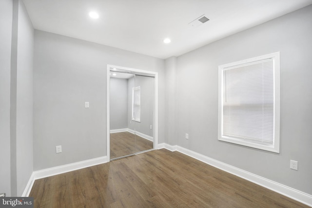 unfurnished bedroom featuring dark wood-type flooring and a closet