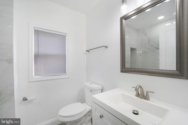 bathroom featuring a shower, vanity, and toilet